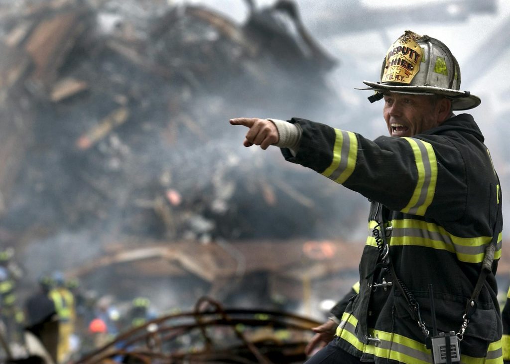 Feuerwehrmann in schwarz-gelber Uniform, der auf etwas zeigt