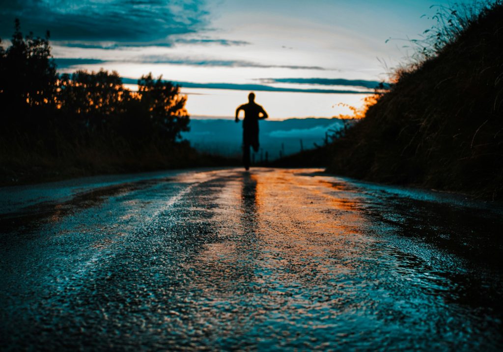 Silhouettenfoto einer Person, die auf der Straße läuft