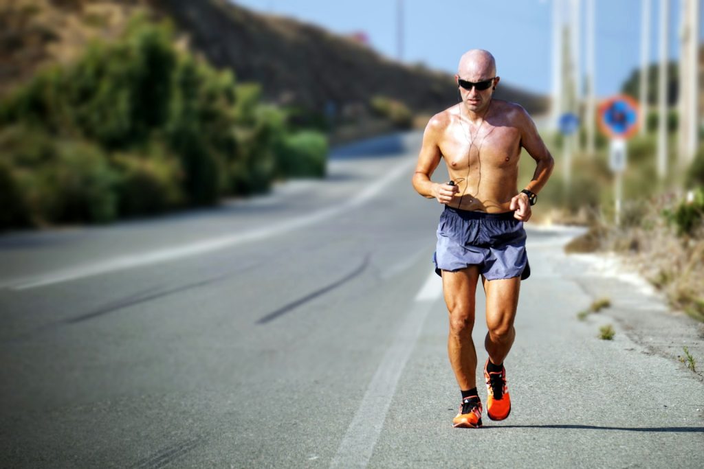 Mann beim Joggen mit schwarzen Kopfhörern am Tag